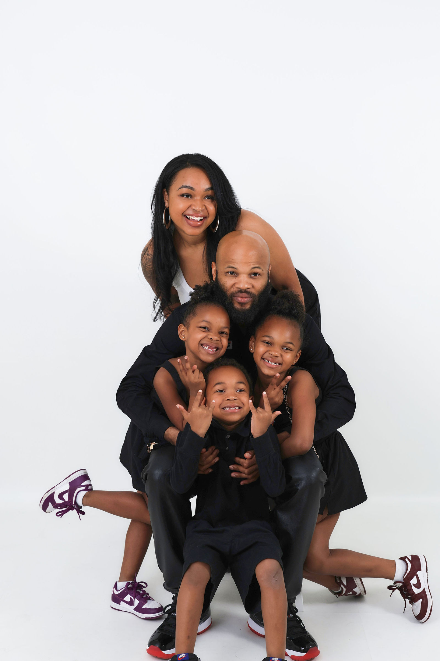 Cute family photo of family posing against white backdrop wearing matching outfits at Muse Studios, Atlanta and Boston's first self-capture photography studio